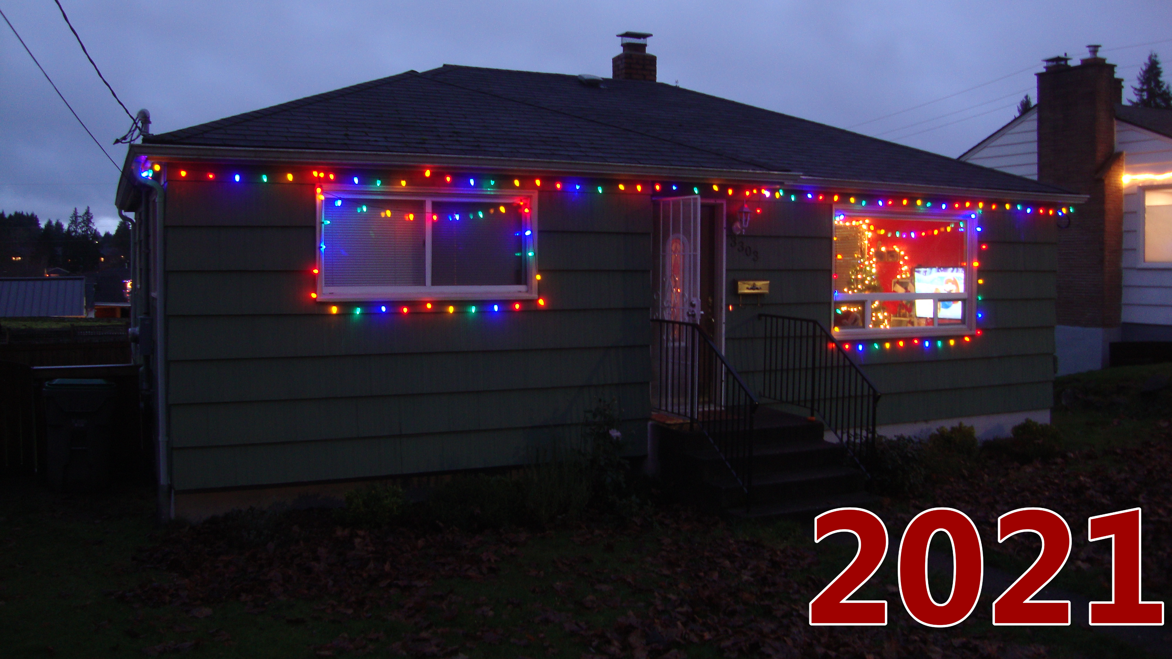 The exterior in 2021. Colorful lights go along the trim and hang low around the window frames.