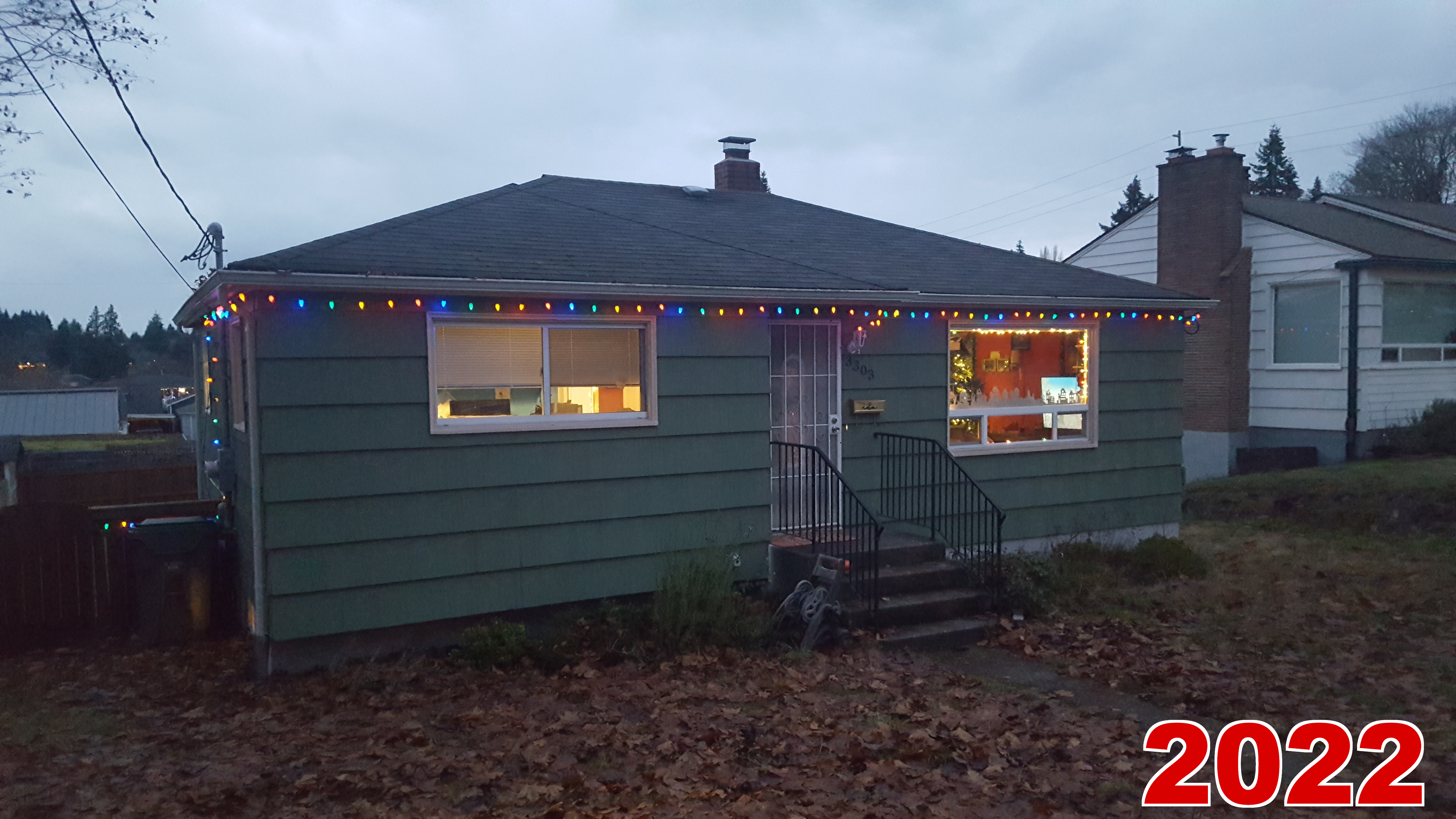 The exterior. Lights only along the trim this time. In the window we've got a cutout christmas village we made, and lights around the interior edge.