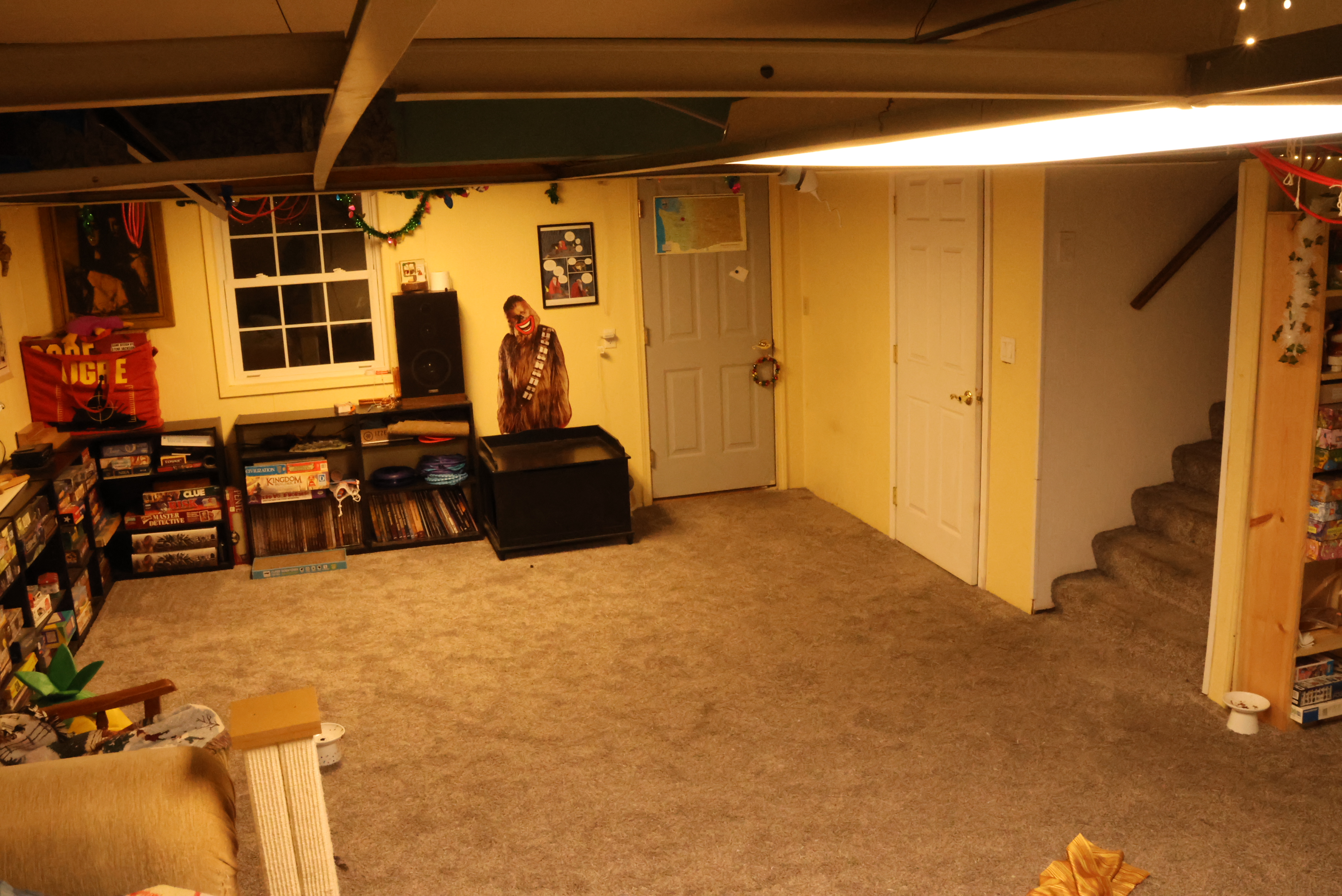 The basement in 2023. Much tidier! There's a new bookshelf I built over against the wall, and the ceiling tiles have all been removed. Since they've been gone Morrie has had way fewer asthma issues when she's down there. 