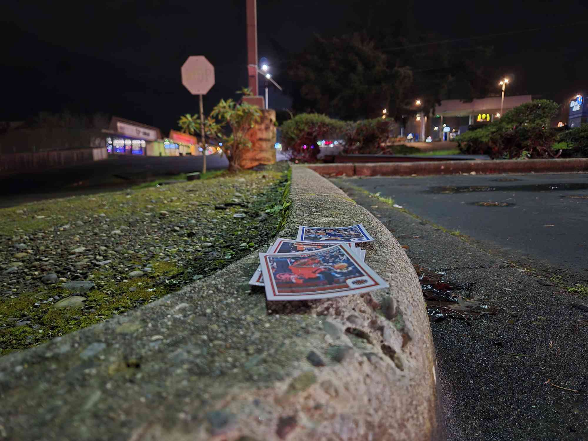 Cards on a parking lot cement barrier at night. 